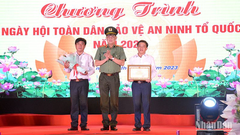 Đại diện Bộ Công an trao tặng Bằng khen cho nhân dân và cán bộ xã Hàm Liêm, huyện Hàm Thuận Bắc đã có thành tích xuất sắc trong phong trào Toàn dân bảo vệ an ninh Tổ quốc. (Ảnh: Đình Châu)