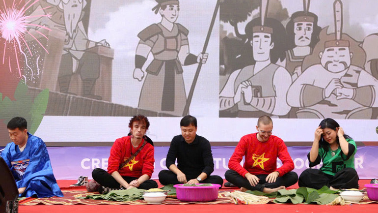 Các thầy cô của Trường đại học Ngoại ngữ, Đại học Quốc gia Hà Nội hướng dẫn các đồng nghiệp quốc tế cách gói bánh chưng, quảng bá nét đẹp văn hóa Việt Nam.