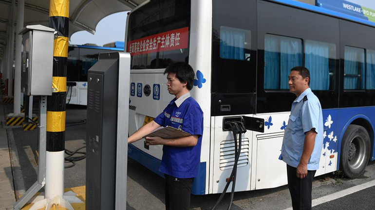 Kiểm tra xe buýt điện tại một trạm sạc ở thành phố Hàng Châu. Ảnh: (Tân Hoa Xã)
