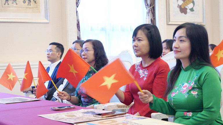 Phu nhân Đại sứ, Hoàng Thị Hương Giang (ngoài cùng bên phải), phu nhân Công sứ, Bùi Thị Hồng Hải (thứ hai từ phải sang) xem cầu truyền hình Lễ diễu binh, diễu hành và Lễ kỷ niệm.