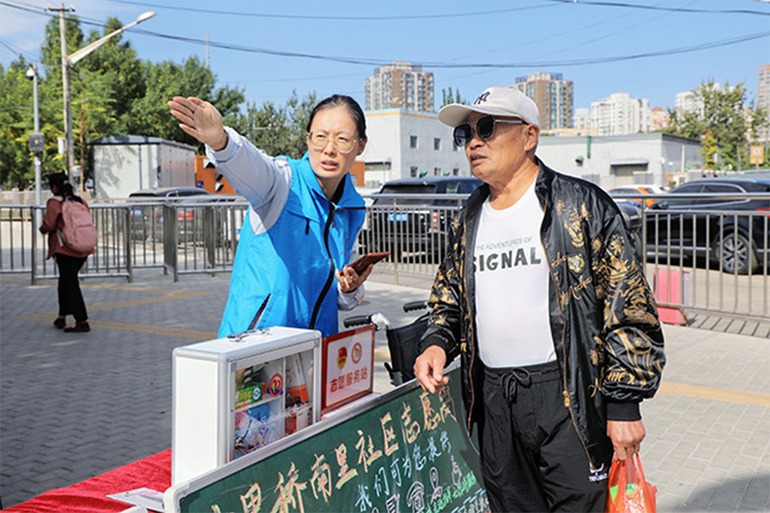 Tình nguyện viên chỉ đường cho du khách ở bến xe khách Liuliqiao, Bắc Kinh. (Ảnh: people.cn)