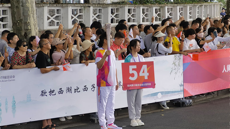 Thành viên rước đuốc thứ 54 chờ tiếp lửa thiêng ASIAD 19. (Ảnh: people.com.cn)
