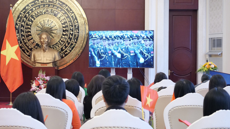 Mọi người chăm chú theo dõi Lễ diễu binh, diễu hành qua màn ảnh nhỏ.