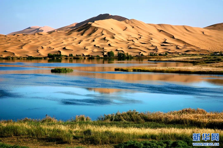 Cảnh sắc nên thơ với mặt hồ, núi cát và đồng cỏ xanh trên sa mạc Badain Jaran. (Ảnh: Tân Hoa Xã)