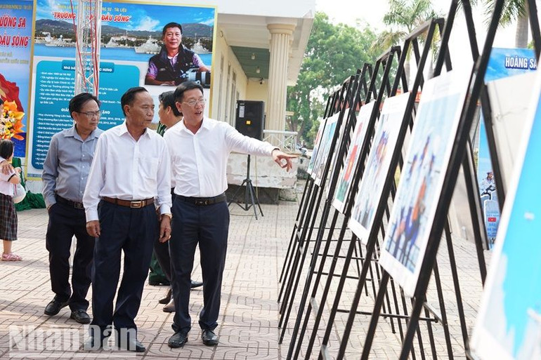 Nhà báo Nguyễn Quốc Hưng giới thiệu những hình ảnh về sinh hoạt, huấn luyện sẵn sàng chiến đấu của cán bộ, chiến sĩ Hải quân chụp ở Quần đảo Trường Sa cho các đồng chí lãnh đạo huyện.