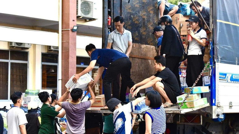 Nhiều người tình nguyện góp công, góp sức bốc xếp hàng hóa lên xe.