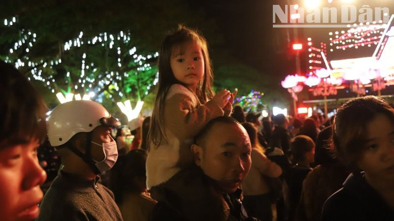 Một em nhỏ được bố mẹ đưa đi xem chương trình.