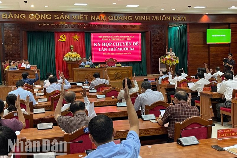 Các đại biểu Hội đồng nhân dân tỉnh Đắk Lắk biểu quyết thông qua Nghị quyết kỳ họp.