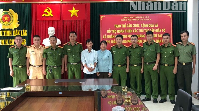 Lãnh đạo Công an huyện Cư M'gar và các đơn vị trực thuộc với vợ chồng anh Phạm Quang Tèo tại buổi trao thẻ căn cước.
