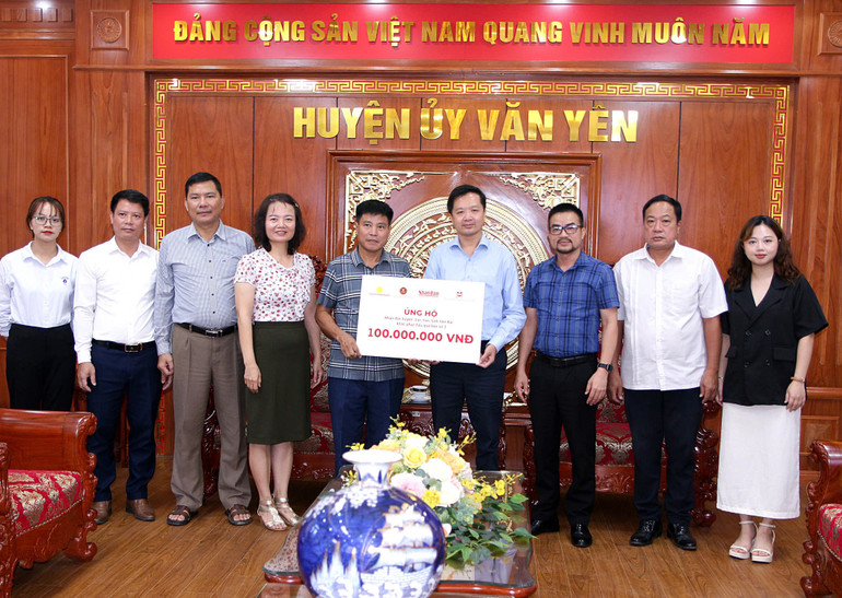 Đại diện Báo Nhân Dân, các nhà tài trợ và lãnh đạo Ủy ban nhân dân huyện Văn Yên, tỉnh Yên Bái, trao và nhận biểu trưng hỗ trợ nhân dân huyện Văn Yên, tỉnh Yên Bái. (Ảnh: THANH SƠN)