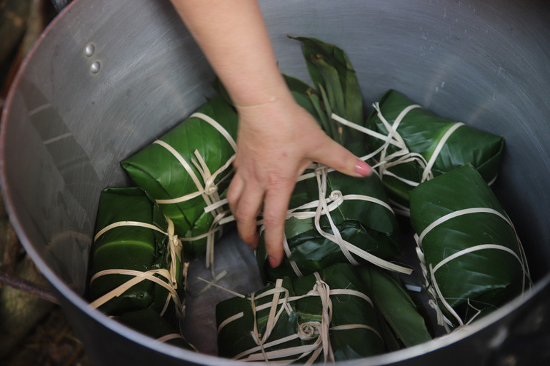 Các nghệ nhân gói 5kg gạo nếp, 1kg đỗ xanh, 1kg thịt lợn… thành 10 chiếc bánh chưng vuông trong thời gian tối đa 10 phút, luộc bánh trong 5 giờ đồng hồ.