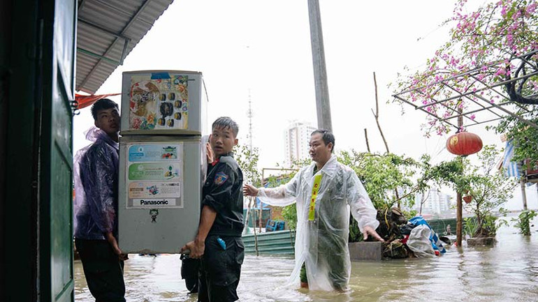 Các chiến sĩ công an tỉnh Hà Nam giúp nhân dân vận chuyển đồ đạc để tránh nước ngập.