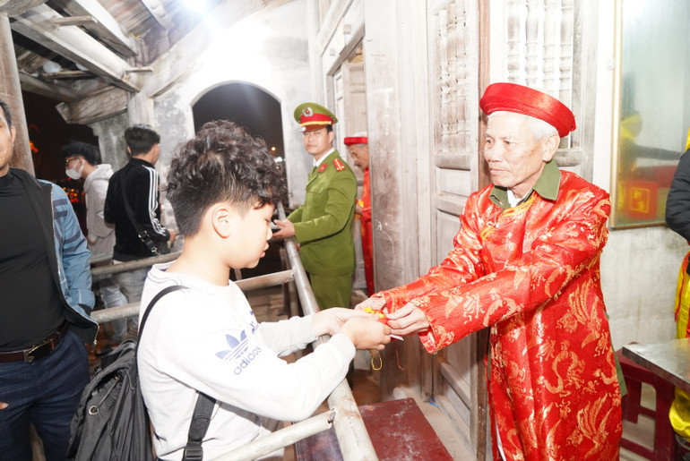 Các bô lão phát lương Đức Thánh Trần tại đền Trần Thương.