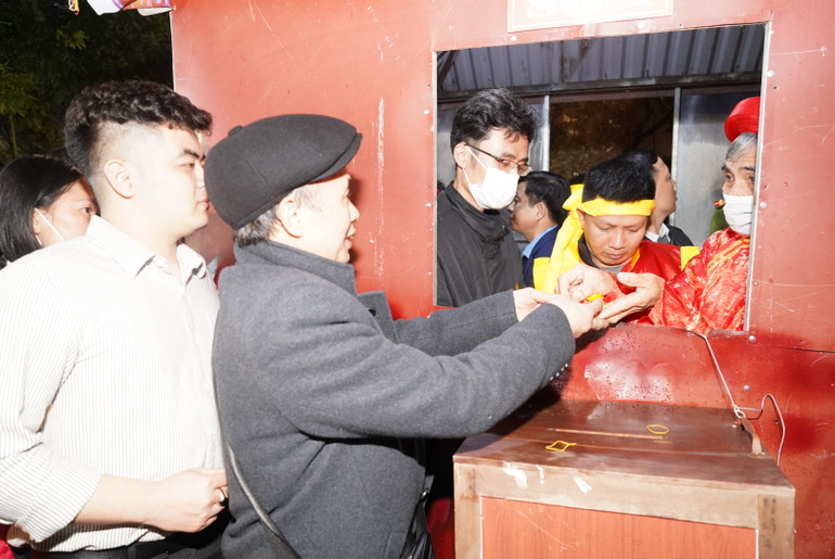 Du khách và nhân dân nhận lương tại các điểm phát lương tại đền Trần Thương.