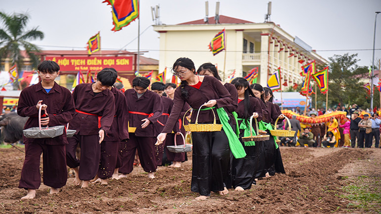 Những nam thanh, nữ tú đi sau gieo hạt giống để cầu mong một năm mới với mùa màng tươi tốt.