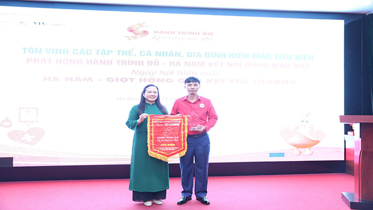 Lãnh đạo Ban Chỉ đạo quốc gia vận động Hiến máu tình nguyện trao cờ và biểu trưng năm 2024 cho Ban Chỉ đạo vận động Hiến máu tình nguyện tỉnh Hà Nam.