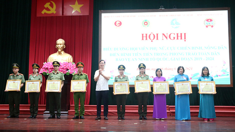 Đồng chí Nguyễn Minh Tiến - Trưởng Ban Dân vận Tỉnh ủy Hà Nam trao Bằng khen của Chủ tịch UBND tỉnh cho các tập thể, cá nhân có nhiều thành tích trong phong trào bảo vệ an ninh Tổ quốc.