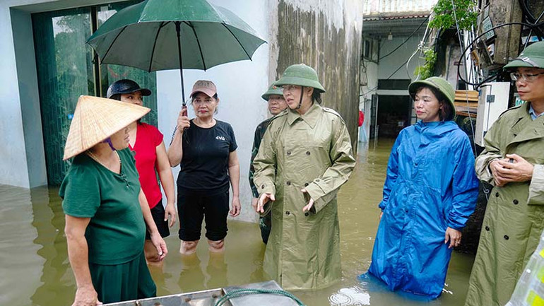 Đồng chí Lê Thị Thủy đến các khu dân cư đang bị ngập lụt do mưa lũ để thăm hỏi, động viên người dân.