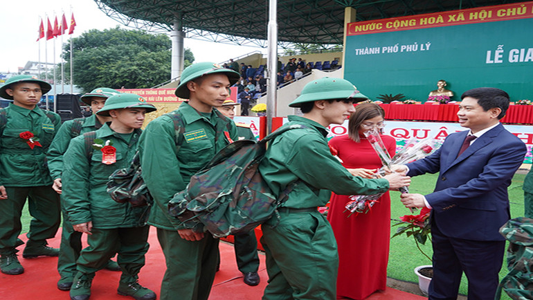Đồng chí Chủ tịch Ủy ban nhân dân tỉnh Hà Nam tặng hoa, động viên thanh niên lên đường nhập ngũ.