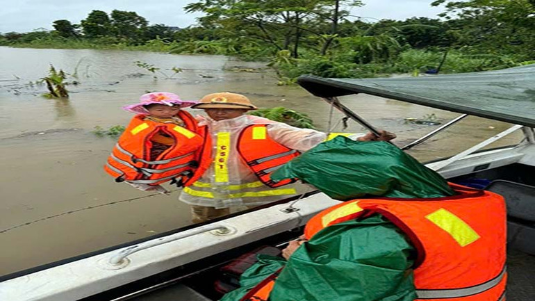 Lực lượng công an giúp đỡ người dân vùng ngập lụt di chuyển đến nơi an toàn