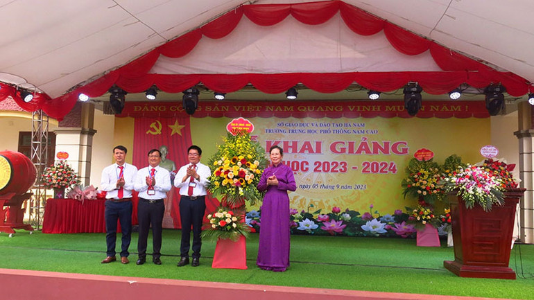 Đồng chí Bí thư Tỉnh ủy, Chủ tịch Hội đồng nhân dân Hà Nam tặng hoa chúc mừng thầy và trò Trường THPT Nam Cao.