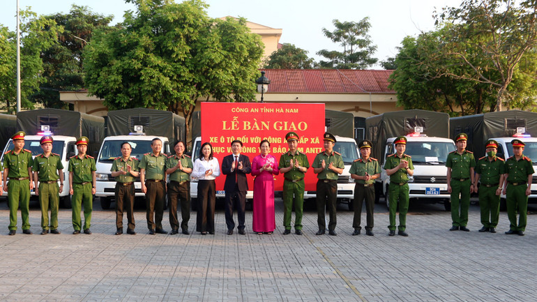 Các đại biểu chứng kiến lễ bàn giao xe ô tô cho lực lượng Công an xã, thị trấn.