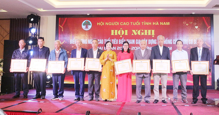 Bà Trần Thị Loan, Chủ tịch Hội Người cao tuổi tỉnh Hà Nam khen thưởng biểu dương người cao tuổi tiêu biểu tham gia xây dựng hệ thống chính trị cơ sở.