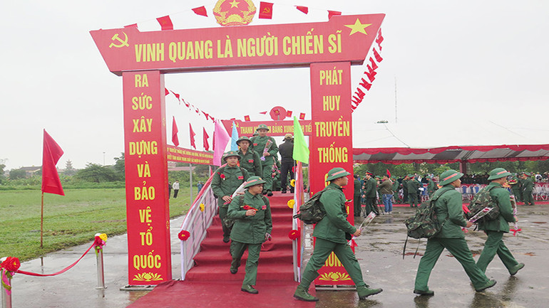 Các thanh niên bước lên cầu vinh quang hăng hái về đơn vị nhận nhiệm vụ.