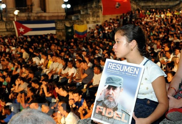 Một khán giả nhỏ tuổi với tấm hình lãnh tụ Fidel Castro tới tham dự Gala “Mãi mãi Fidel”. (Ảnh: TTXVN)