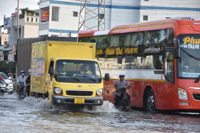 Người dân và phương tiện di chuyển khó khăn qua khu vực Vòng xoay Trung Lương, thành phố Mỹ Tho (Tiền Giang) vào chiều 11/3.