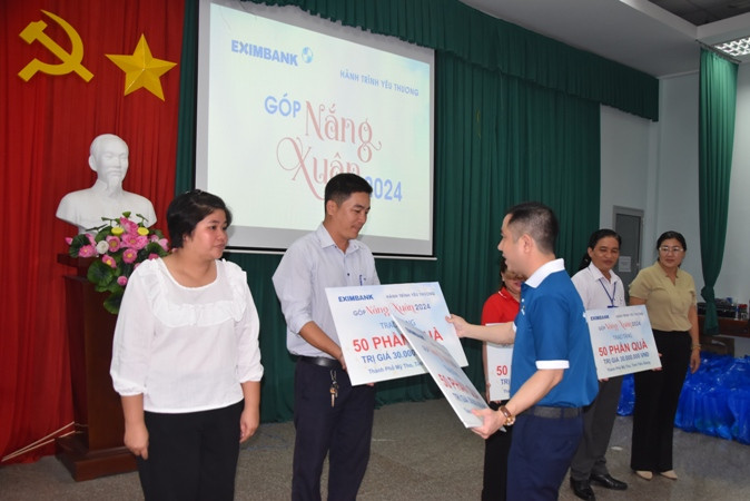 Trao bảng tượng trưng cho các đơn vị có người dân nghèo đến nhận quà.