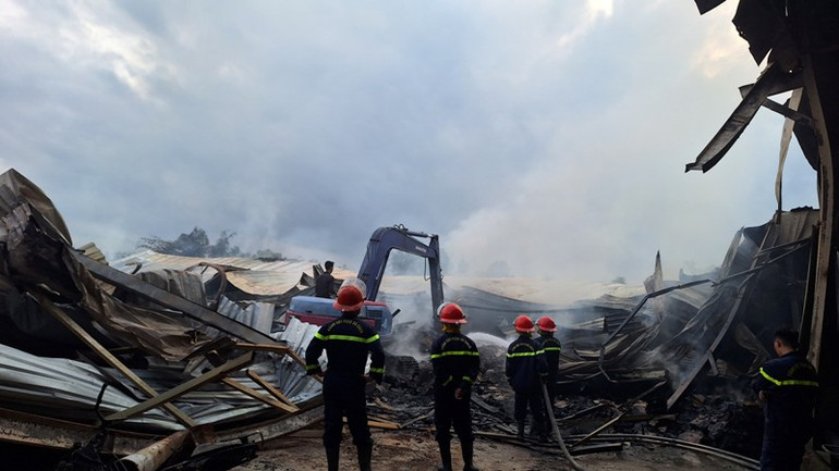 Sáng 17/4, lực lượng dùng máy Ko-be xới tung đống đổ nát để tiếp tục chữa cháy.