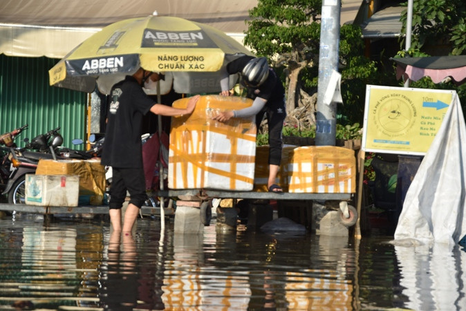 Người dân cơi nới đồ đạc khi triều cường lên cao.