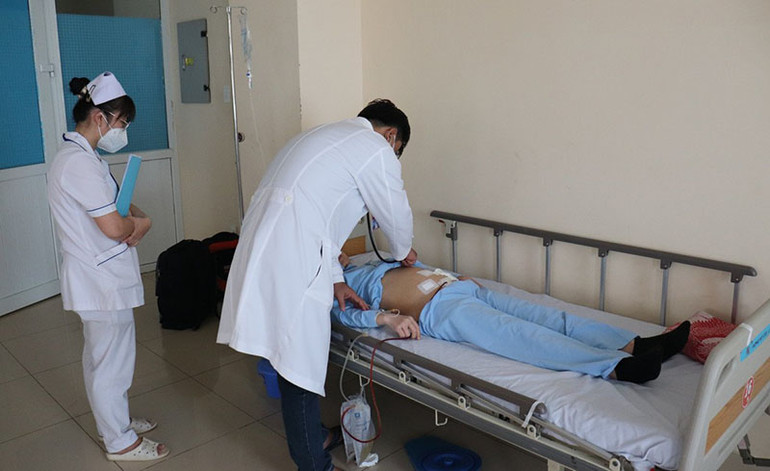 Sau khi phẫu thuật thành công, các bác sĩ đến thăm khám cho bệnh nhân.