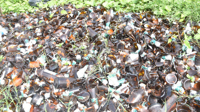 Hiện trường vỏ chai bia thủy tinh bị bể nằm chất đống ven quốc lộ 1.