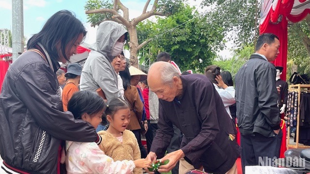 Nghệ nhân Hoàng Choóng giới thiệu sản phẩm gà đất gáy cho trẻ nhỏ.