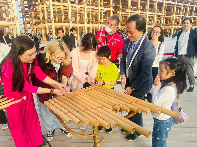 Phó Tổng đại diện Việt Nam tại EXPO 2025 Osaka Trần Nhất Hoàng giới thiệu nhạc cụ truyền thống của Việt Nam.