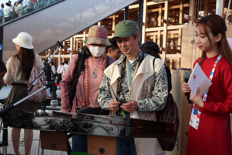 Du khách thích thú trải nghiệm nhạc cụ truyền thống Việt Nam.