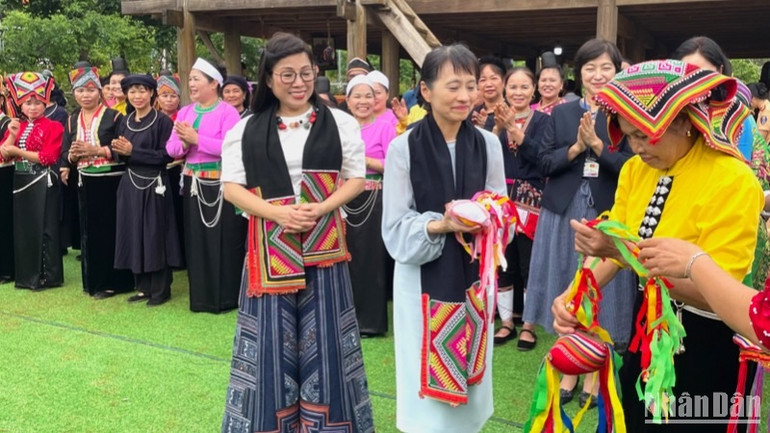 Đại diện nhóm đồng bào dân tộc Thái trân trọng tặng hai phu nhân quà lưu niệm.