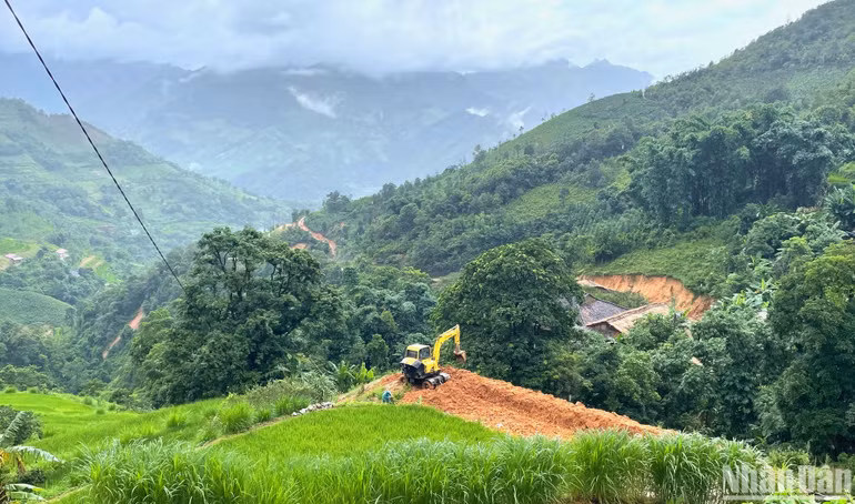 Xe ủi đang múc đất làm công trình.