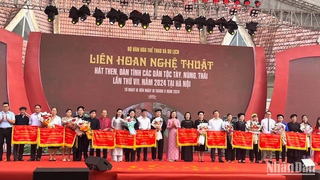 Đại diện ban tổ chức tặng hoa và cờ cho các đoàn tham dự liên hoan.