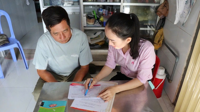 Cán bộ tín dụng của Ngân hàng Chính sách xã hội thăm, hướng dẫn hộ vay vốn tại Kiên Giang.
