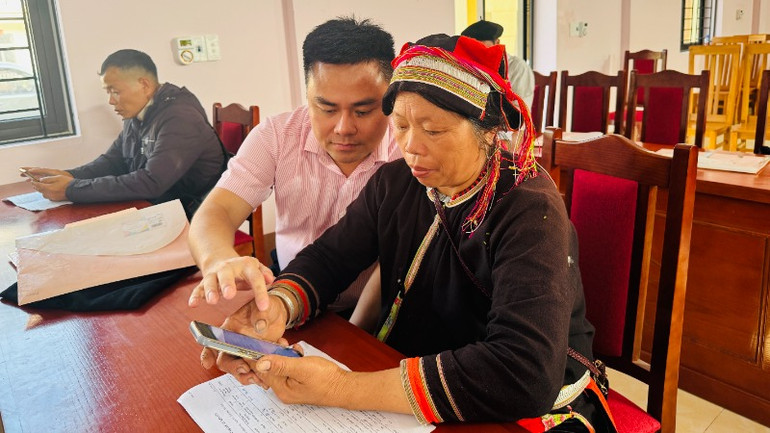 Cán bộ Ngân hàng Chính sách xã hội hướng dẫn bà con sử dụng ứng dụng moblie quản lý tín dụng chính sách.