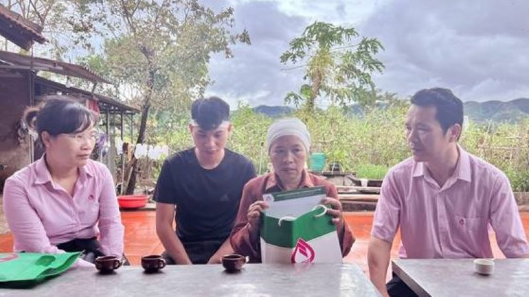 Phó Tổng Giám đốc Hoàng Minh Tế (bên phải) động viên, chia sẻ với gia đình bà Đinh Thị Song ở thôn Thùng Thìn, xã Biển Động, huyện Lục Ngạn.