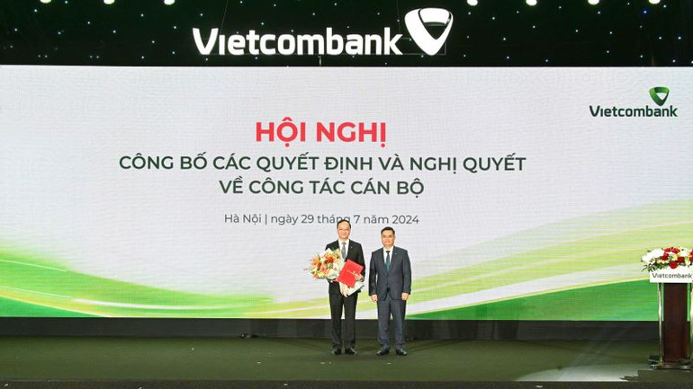 Bí thư Đảng ủy, Chủ tịch Hội đồng quản trị Vietcombank Nguyễn Thanh Tùng (bên phải) trao Quyết định và tặng hoa chúc mừng ông Lê Quang Vinh.