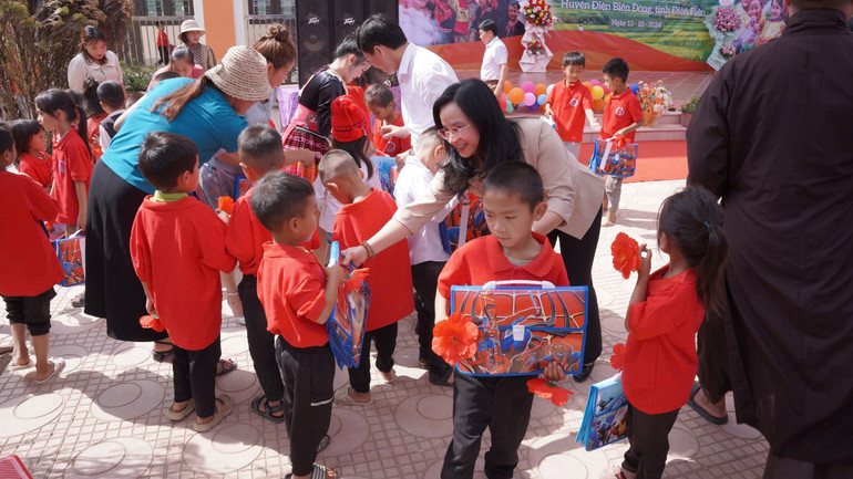 Trao tặng các suất quà gồm cặp sách và đồ dùng học tập tới các em học sinh.