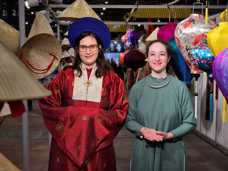 Amelie Bernard và Maeva Mounier thích thú khi được diện trên mình chiếc áo dài truyền thống của Việt Nam. (Ảnh: MINH DUY)