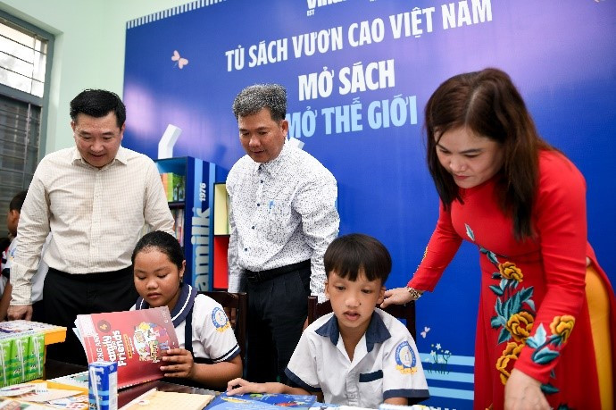 Các em học sinh khám phá tủ sách mới do Vinamilk trao tặng tại thư viện trường.