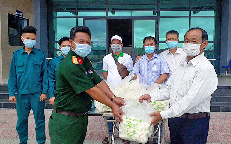 Ông Nguyễn Văn Nhiệm (ngoài cùng bên phải) mang các sản phẩm của trang trại tới ủng hộ lực lượng tuyến đầu phòng, chống dịch Covid-19.