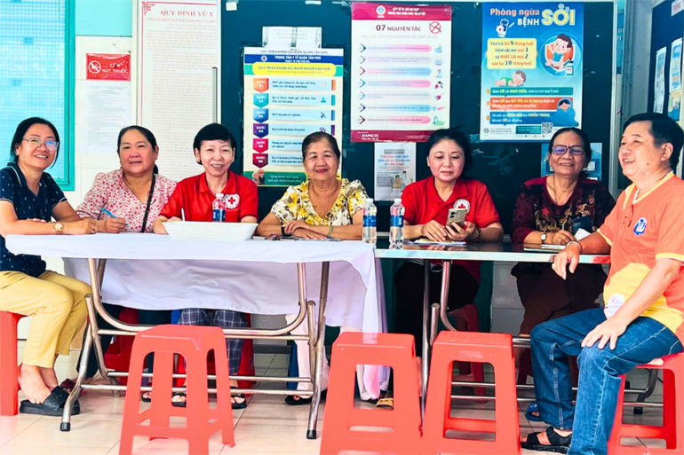 Dù là ngày lễ, cộng tác viên sức khỏe cộng đồng vẫn nhiệt tình hỗ trợ phụ huynh tại điểm tiêm ở quận Tân Phú.